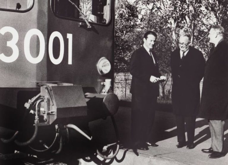 Company founder Gunnar Dellner with customers in front of passenger train