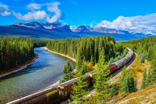 Długi towarowy pociąg poruszający się wzdłuż Bow River w Canadia, Rockies